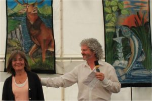 Philip and Stephanie Carr-Gomm at the 50th anniversary celebrations for the modern Druid Order in 2104. Stephanie painted the banners in the background where you can see the Salmon of Wisdom in the West and the Stag in the heat of Summer in the north or south depending on your hemisphere.